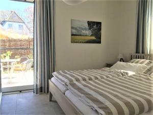 a bedroom with a bed and a view of a patio at Compass-App-5 in Hohwacht