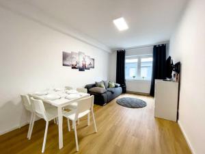 a living room with a white table and white chairs at Cosy & Central Apartments in Gelsenkirchen
