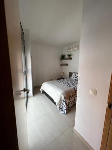 1 dormitorio con 1 cama en una habitación blanca en Loft Sant Jordi by Lofties, en Terrassa