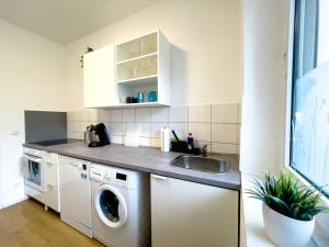 a kitchen with a sink and a washing machine at Cosy & Central Apartments in Gelsenkirchen