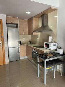 eine Küche mit einem Kühlschrank aus Edelstahl und einer Mikrowelle in der Unterkunft Loft Sant Jordi by Lofties in Terrassa