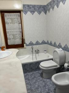 a bathroom with a toilet and a tub and a sink at DIP IN SICILY in Lentini +54 photos