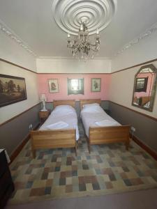 a bedroom with two beds and a chandelier at Les Fleurs Accommodation in Dover