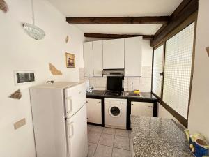 a kitchen with a white refrigerator and a dishwasher at Appartamento Nassia 2 By La Via Del Mare Viaggi e Vacanze in Villasimius