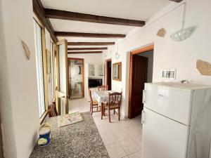 a kitchen with a white refrigerator and a table at Appartamento Nassia 2 By La Via Del Mare Viaggi e Vacanze in Villasimius