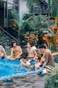 un grupo de personas sentadas en una piscina en Republic Hostel Cat Ba, en Cat Ba