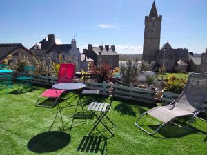 a group of chairs and a table in a yard at Maison centre bourg Port-Bail in Portbail +32 photos