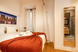 リスボンにあるAkicity Baixa In IIのベッドルーム1室(オレンジの毛布付きのベッド1台付)
