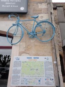 uma bicicleta azul pendurada no lado de um edifício em Maison de location saisonnière en Périgord Vert em Saint-Front-la-Rivière