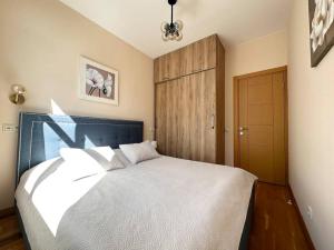 a bedroom with a large bed and a wooden door at Modern building on Rustaveli Ave in Okrokana