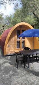ein kleines Zelt mit einem Tisch und einem blauen Schirm in der Unterkunft Campeggio Gianna Golfo dei Poeti in Lerici