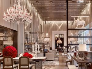 a restaurant with tables and chairs and a chandelier at Baccarat Hotel and Residences New York in New York