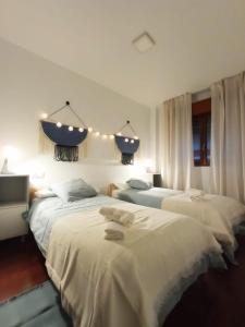 two beds in a bedroom with lights above them at Apartamento Jacaranda in Murcia