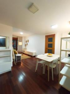 cocina y sala de estar con mesa blanca y sillas en Apartamento Jacaranda en Murcia