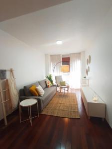 een woonkamer met een bank en een tafel bij Apartamento Jacaranda in Murcia