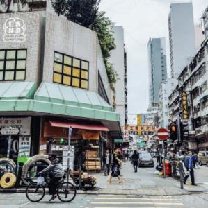 a person riding a bike on a busy city street at 香港木居共享民宿近旺角站高樓層大窗戶舒適乾淨 提前30分鐘聯繫房東入住事宜 in Hong Kong