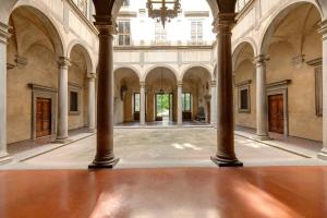 an empty hall with columns and a chandelier at Alfani Deluxe Apartment by Mamo Florence in Florence