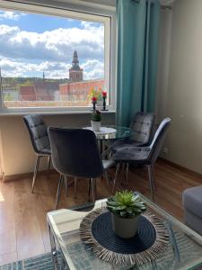een woonkamer met een tafel en stoelen en een groot raam bij Apartament Centrum in Lidzbark Warmiński