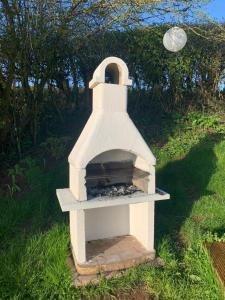 a white brick oven sitting in the grass at The Gannah Farm Shepherds Hut in Hereford