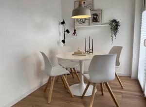 a dining room with a table and white chairs at Ferienwohnung an der Saar in Konz