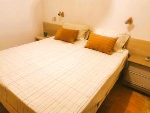 - un lit avec des oreillers orange dans l'établissement House Holiday Brasil Barra do Cunhau, à Barra do Cunhaú