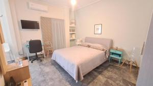 a bedroom with a bed and a desk and a television at Karystos sea side apartment in Karistos