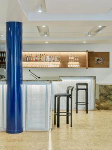 a bar with two black stools in a room at Hôtel Rosalie in Paris