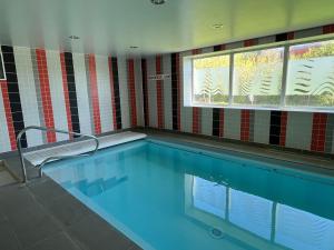 - une piscine dans une chambre avec fenêtre dans l'établissement DOMITYS Le Vallon des Bois, au Mans