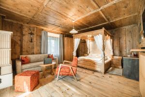 une chambre avec un lit et un canapé dans une pièce dans l'établissement Ansitz Zehentner, à Laion