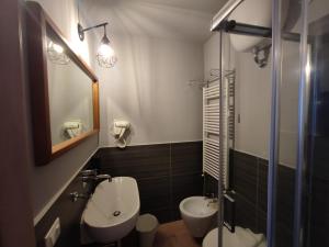a bathroom with a sink and a toilet and a mirror at Romalive Hotel in Rome