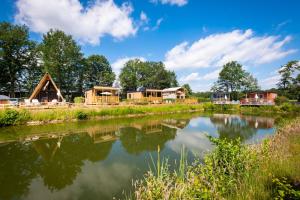 a group of lodges next to a river at Papillon Country Resort in Denekamp