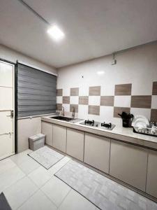 - une cuisine avec un évier et un comptoir dans l'établissement Rumah 127 - Homestay Taiping, à Simpang
