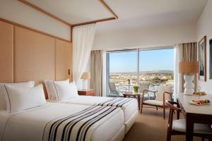 um quarto de hotel com uma cama e uma grande janela em Tivoli Marina Vilamoura em Vilamoura