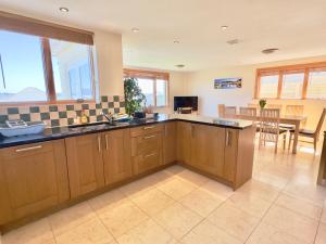 a kitchen with wooden cabinets and a dining room at Pendennis in Padstow