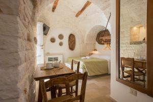 a room with a table and a bed and a bedroom at Trulli Holiday Albergo Diffuso in Alberobello