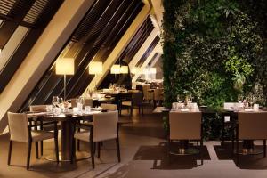 a restaurant with tables and chairs and plants at Tivoli Marina Vilamoura in Vilamoura