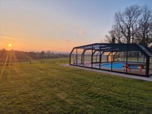 a gazebo with a pool in a field at Sandpiper Cottage in Llanboidy