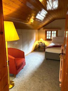 een slaapkamer met een bed en een stoel in een kamer bij Chalet St-François in Ollon