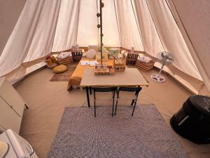 a room with a table and chairs in a tent at Glamping Bieszczady z basenem in Solina