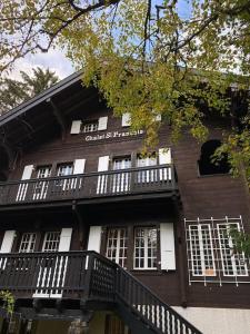 een zwart gebouw met witte ramen en een balkon bij Chalet St-François in Ollon