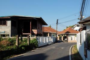 una calle vacía en una casa con una valla en GrandmaD en Chiang Rai