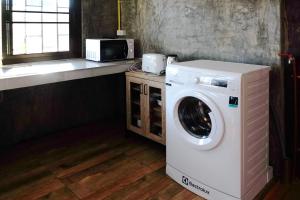 a washing machine in a kitchen with a microwave at GrandmaD in Chiang Rai