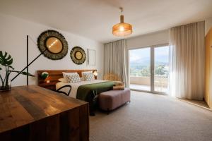 a bedroom with a bed and a large window at Le Balamina in Porto-Vecchio
