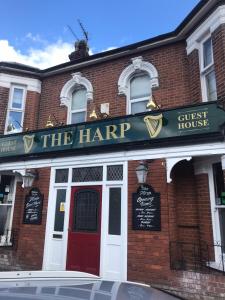 a brick building with a sign that reads the harp house at The Harp Freehouse and Guesthouse in Ipswich