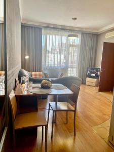 a living room with a table and a couch at Arcada Apartments in Odesa