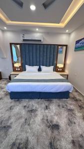 a bedroom with a large bed with a blue headboard at SEAVIEW HOTEL in Umm Lajj
