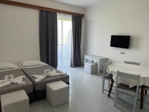 Pokój z 2 łóżkami, stołem i telewizorem w obiekcie Smart Accommodation Rhodes w mieście Rodos