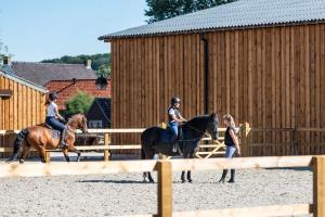 a group of people riding horses in front of a fence at B@B Martinushoeve in Oudenaarde