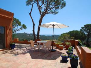 a patio with a table and chairs and an umbrella at Pinetells in Begur
