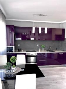 a kitchen with purple cabinets and a dining table at Luxurious Accommodation in Floreşti